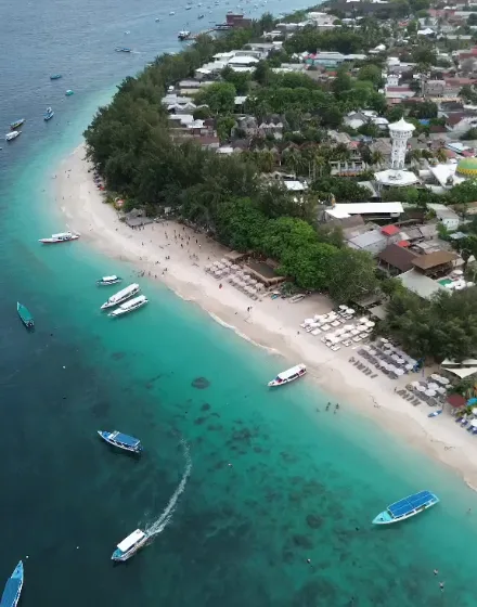 Aerial view of a turquoise Lombok coastline with fishing boats